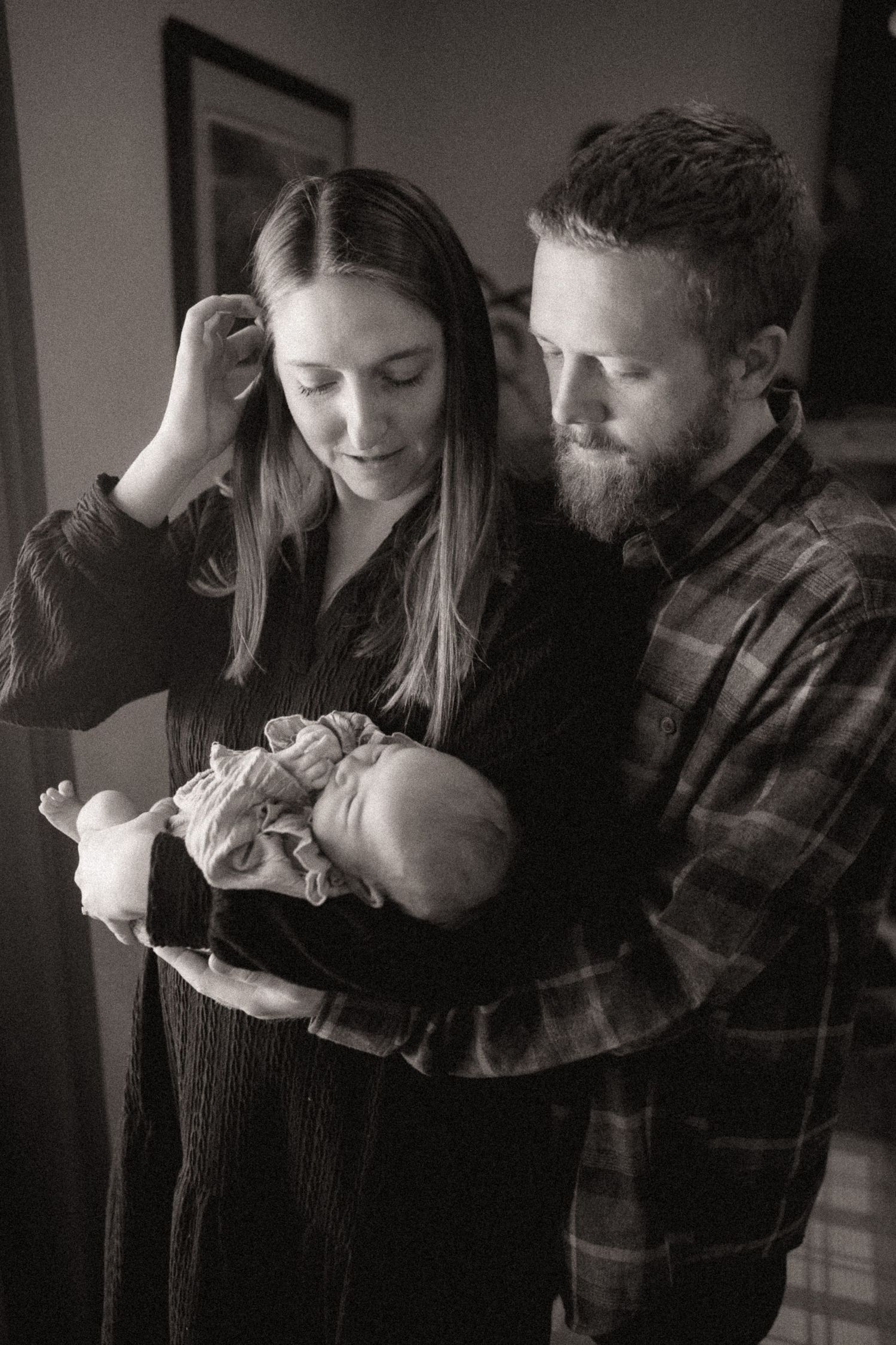 Black and white photo series capturing intimate family moments in moody lighting.