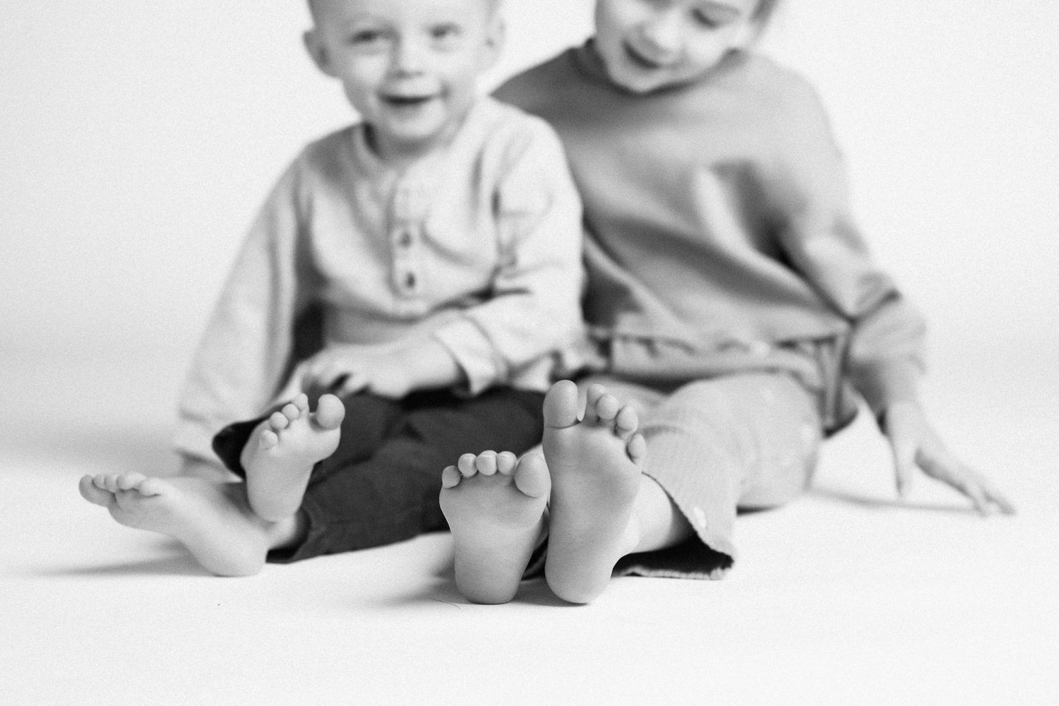 A series of black and white photographs showing a baby's developmental milestones while lying on a white backdrop.