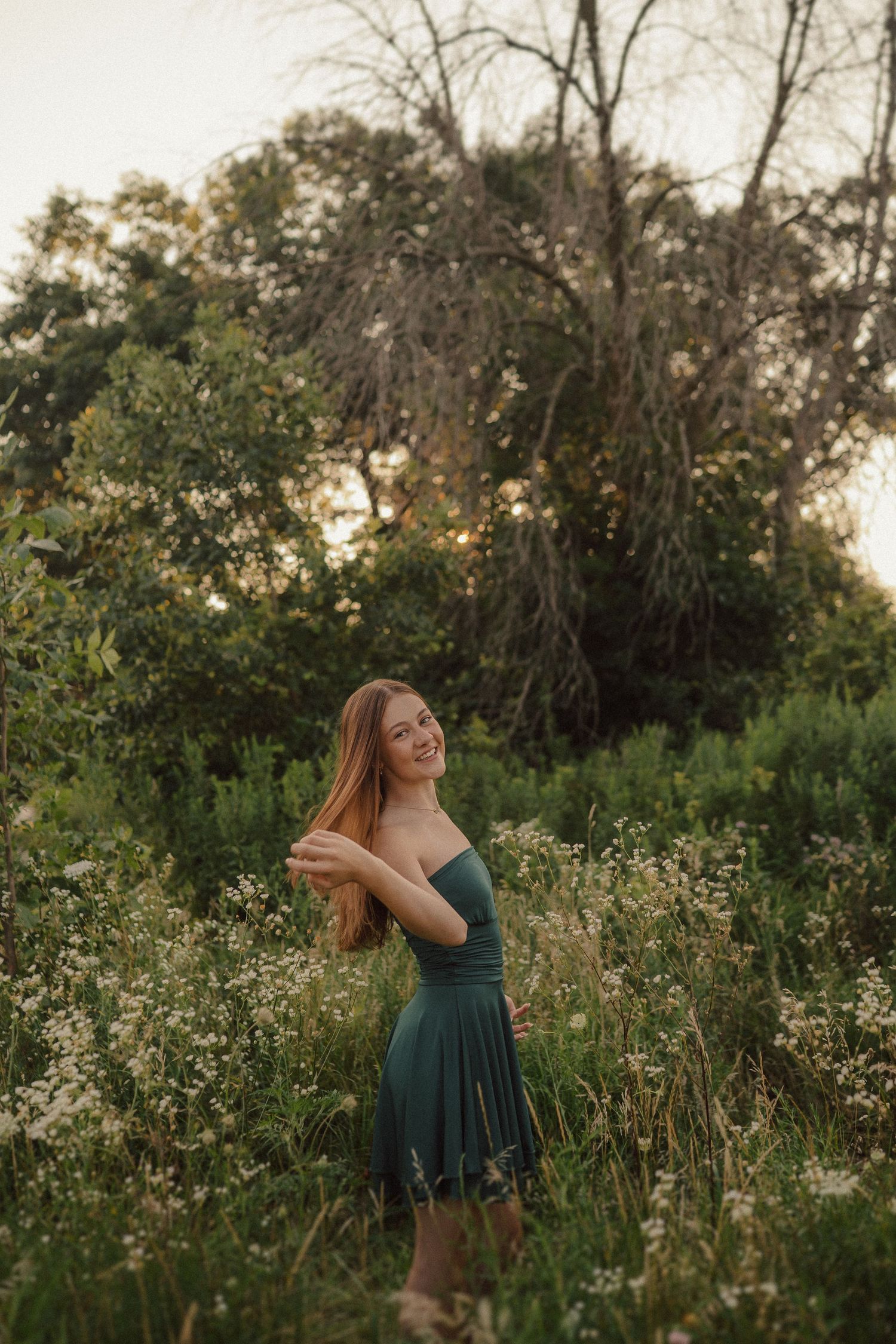 Summer portrait session in a wildflower field at sunset with natural lighting.