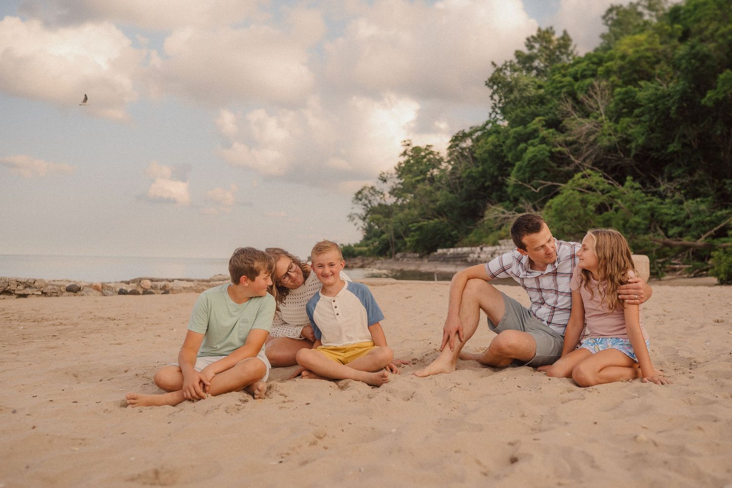 Group lounging together on a scenic beach with lush greenery in the background.