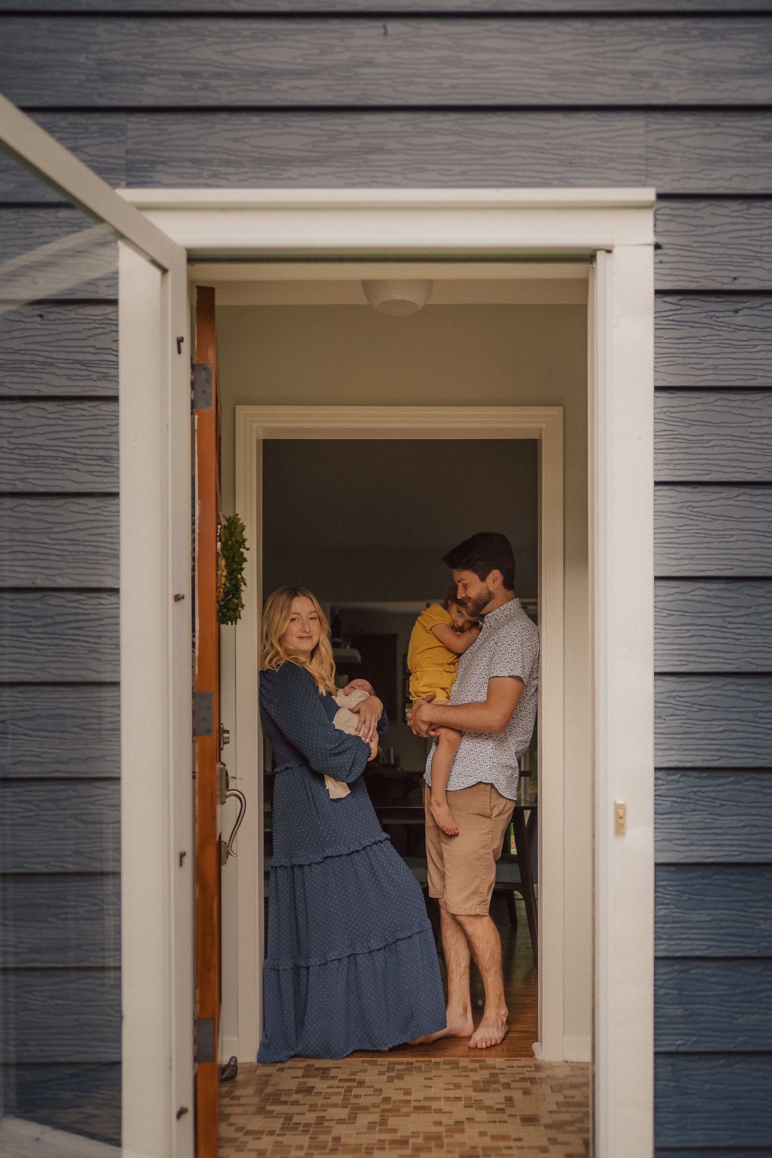 Progressive shots of a family gathering in a white doorframe against gray siding.