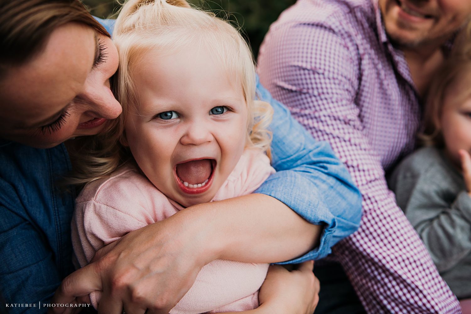 Candid moment captures pure joy and laughter during family portrait.