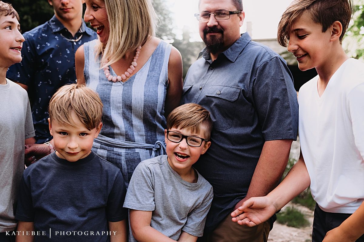 A casual family gathering outdoors with everyone dressed in blue and grey tones.