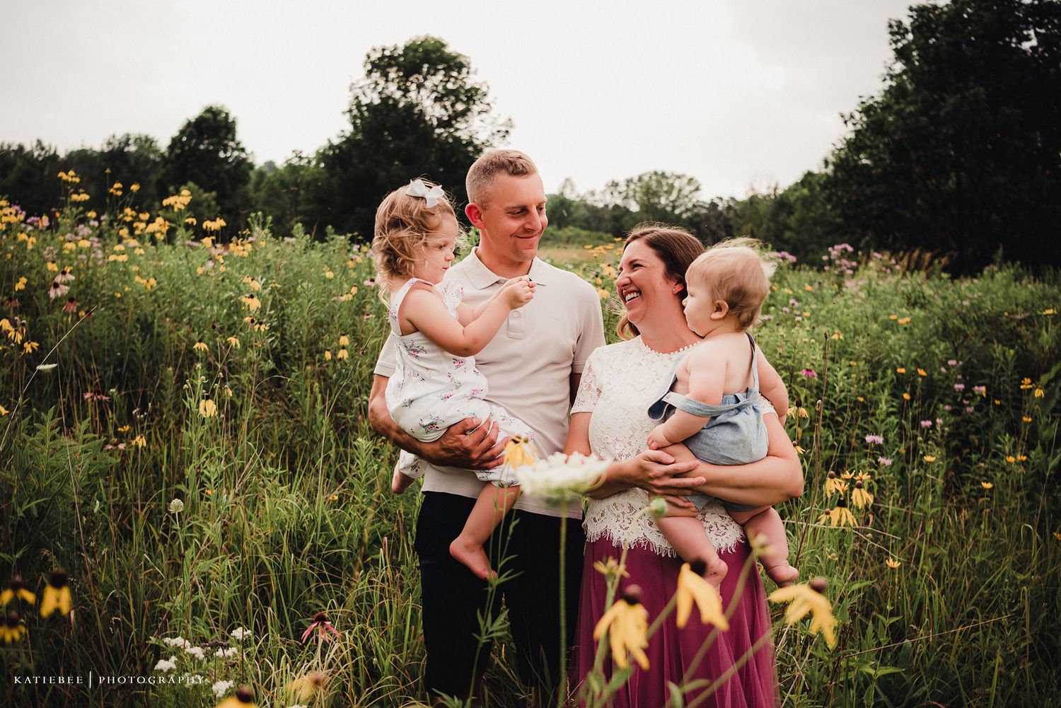 Happy family enjoying a candid moment together in a field of blooming wildflowers.