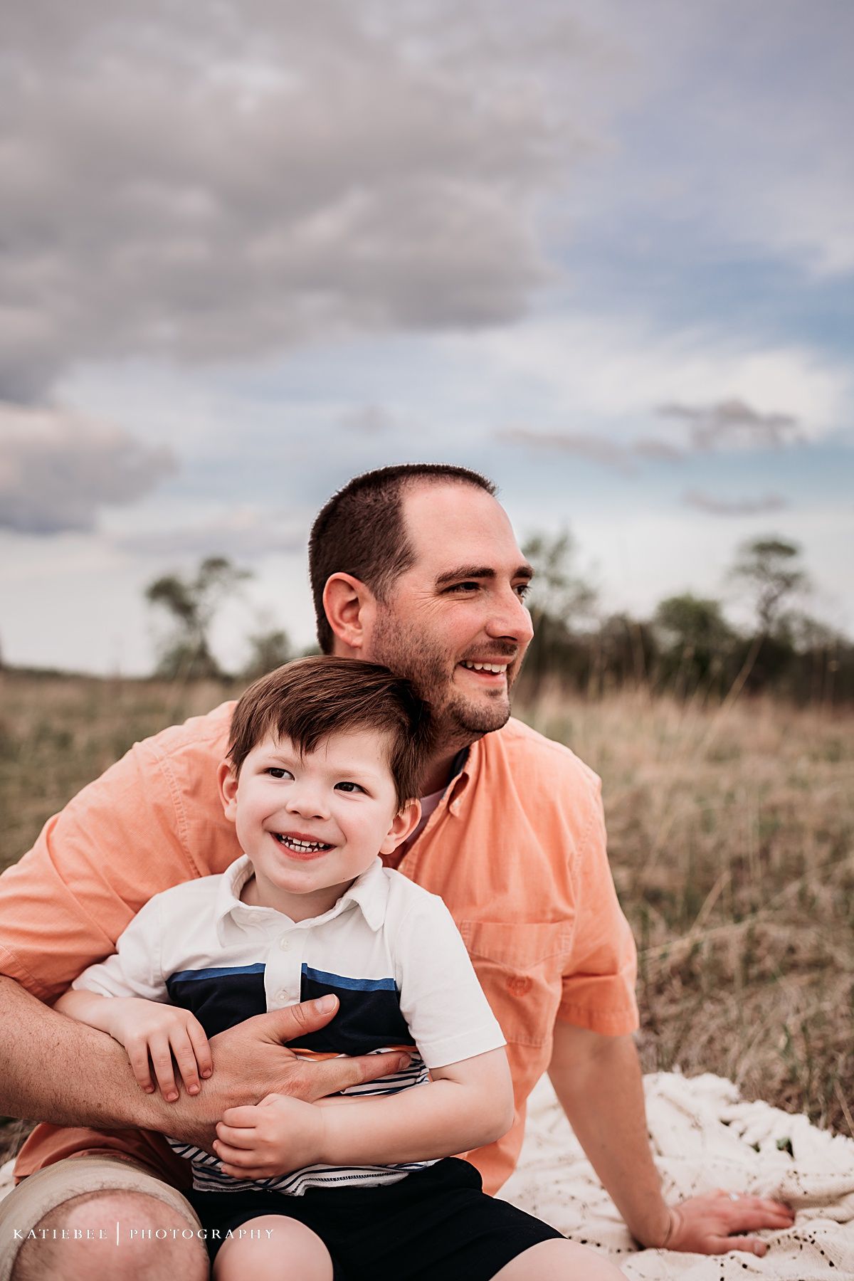 An intimate portrait showing shared joy and connection while sitting outdoors.