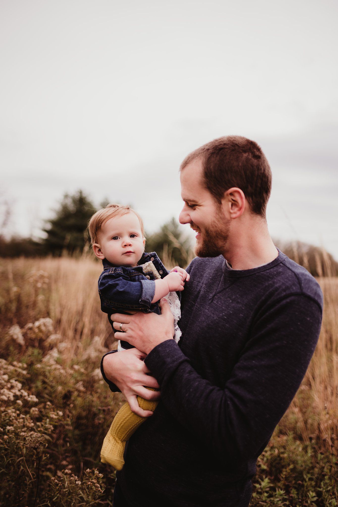 A joyful moment shared between two people in a field of autumn grass.