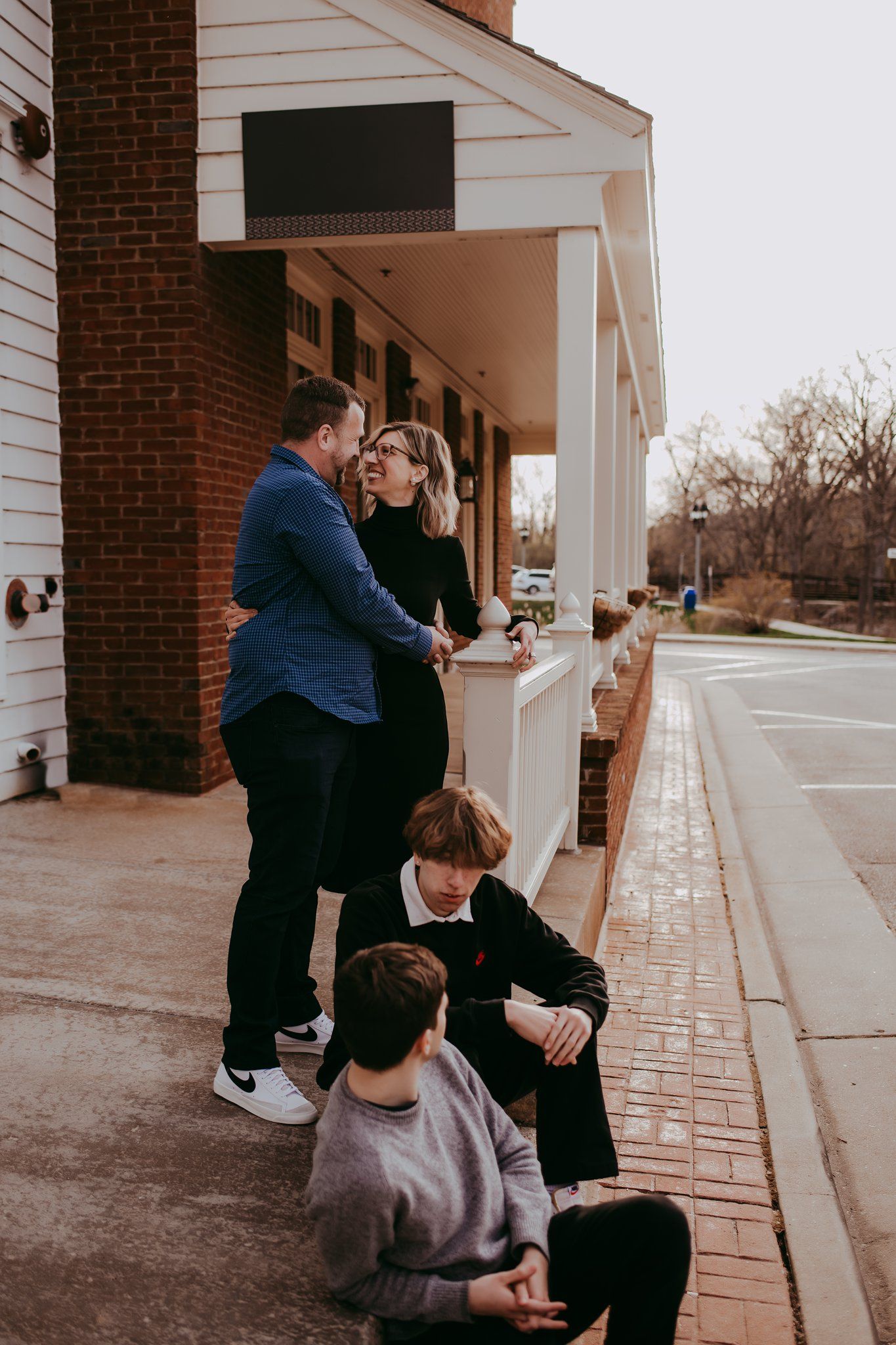 Candid moment of people relaxing outside a brick building with white columns.