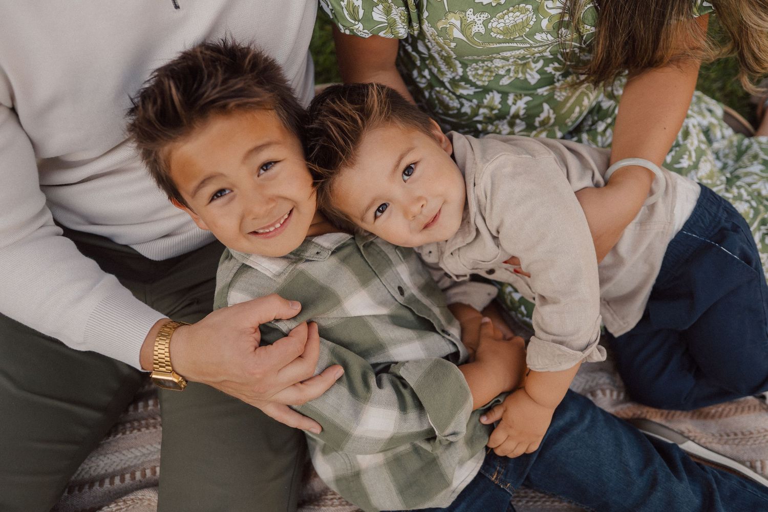 Candid lifestyle photos show family members embracing and laughing together outdoors.