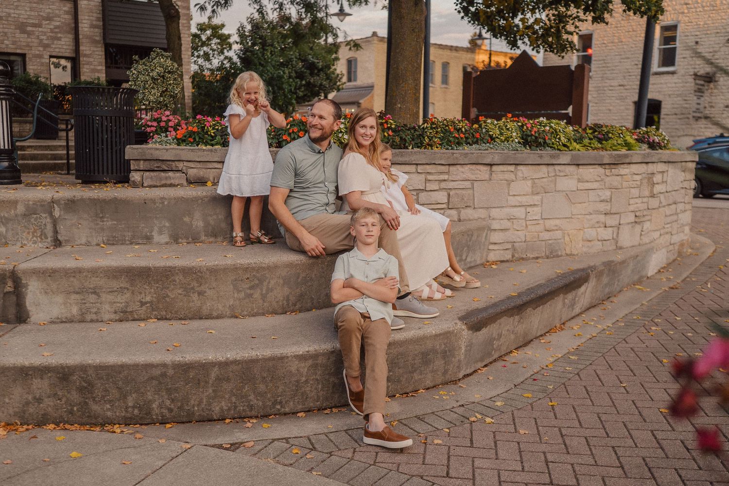 People sitting together on outdoor stone steps in a charming urban setting at sunset.