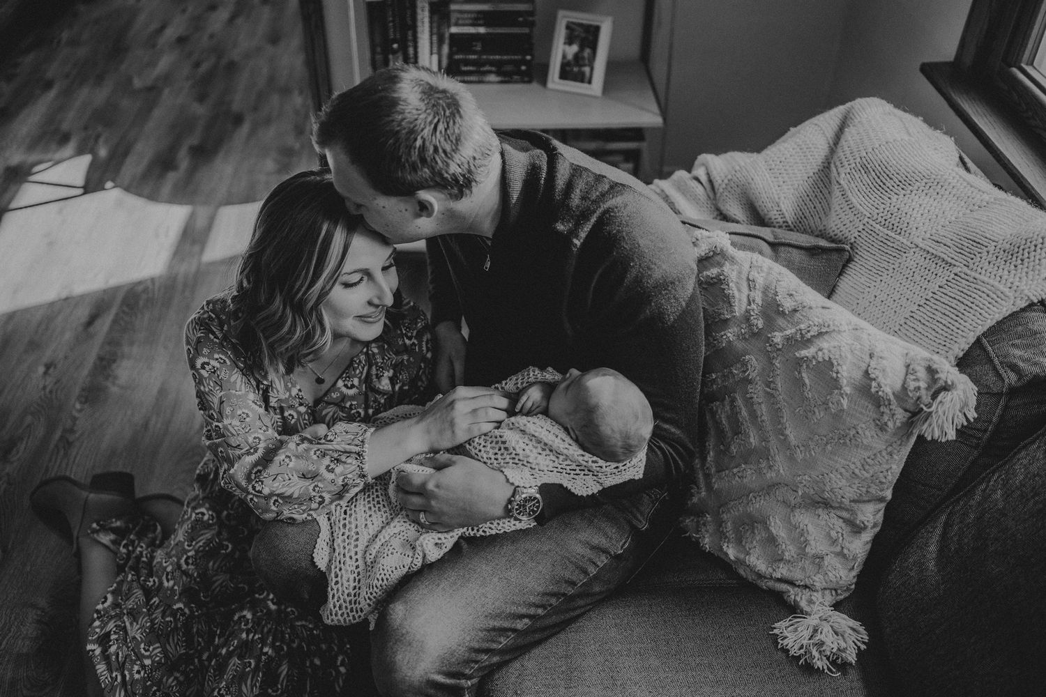 A black and white portrait of a family bonding with their newborn.