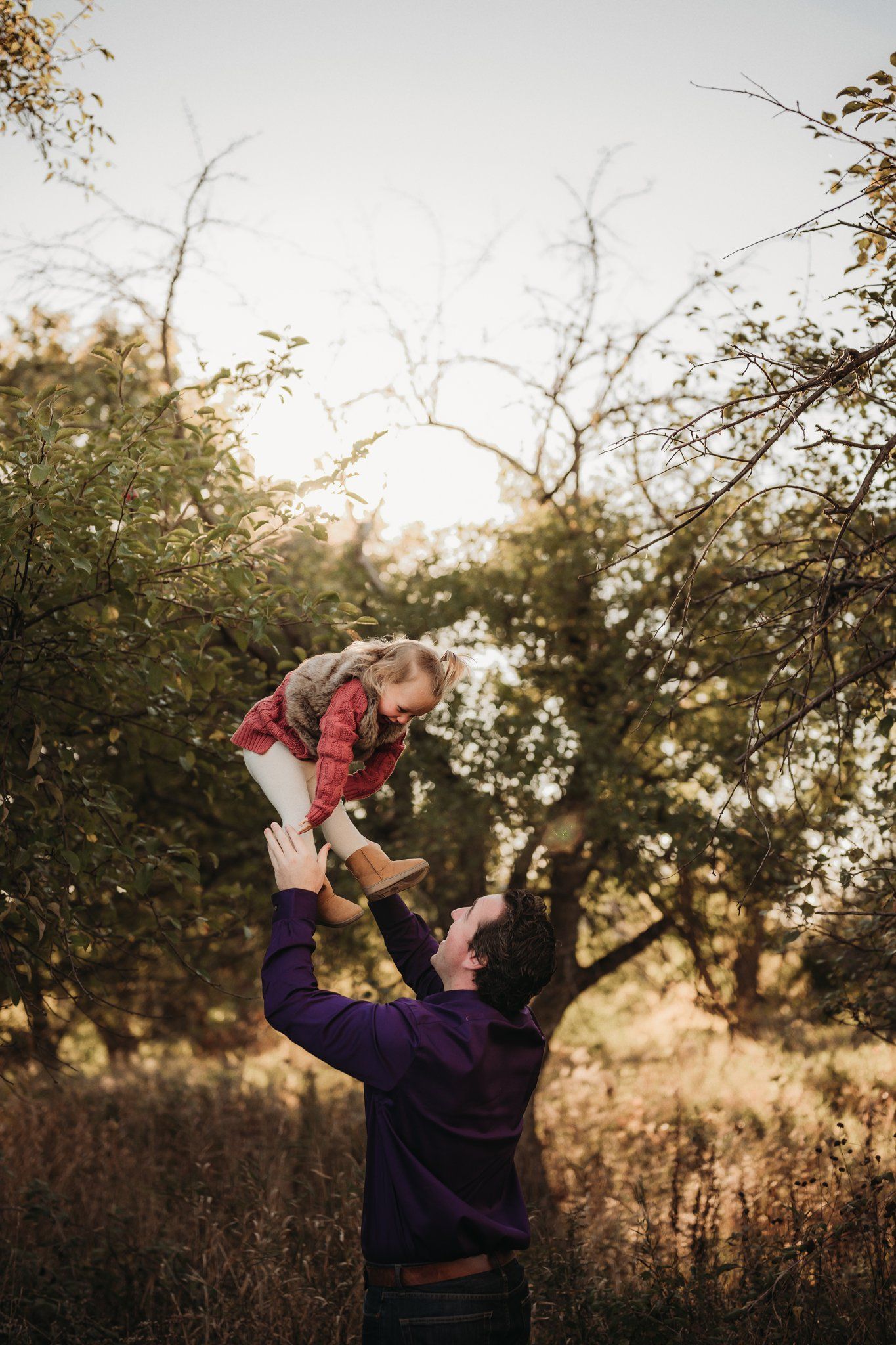 Playful moment captured in golden sunlight through tree branches.