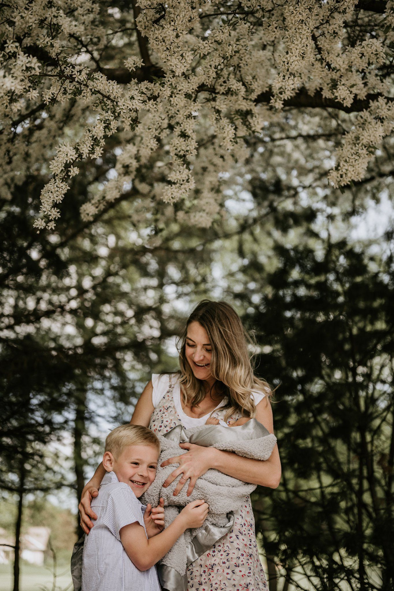 Joyful outdoor family portrait under blooming spring trees.
