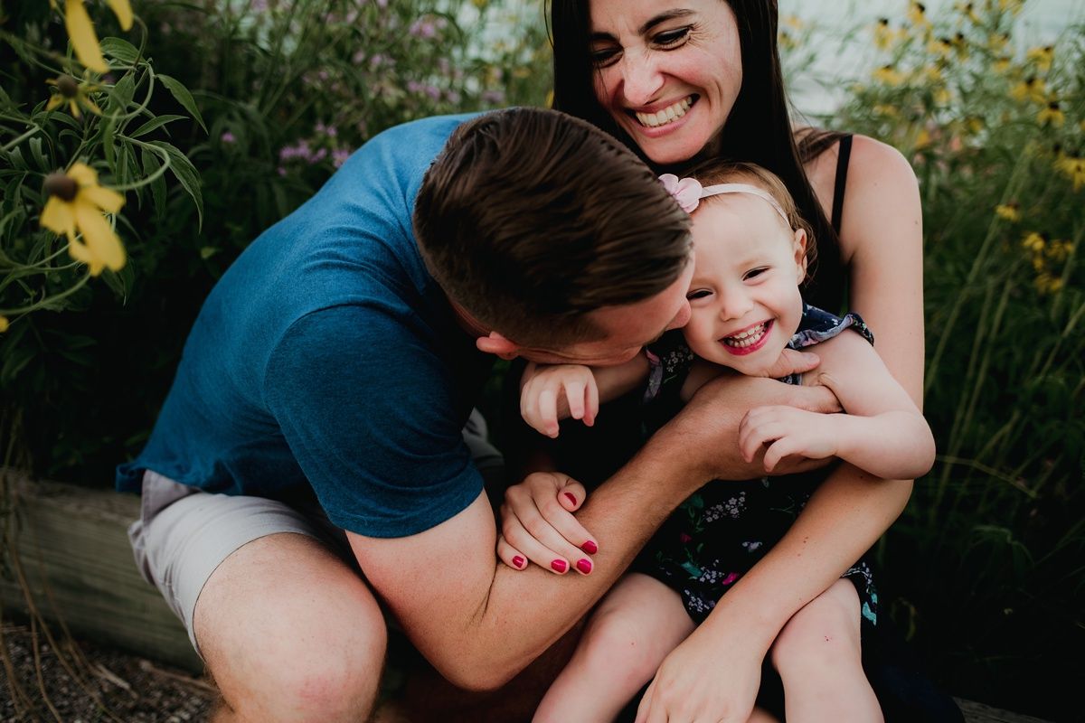 A joyful family moment captured in a garden setting with yellow flowers.