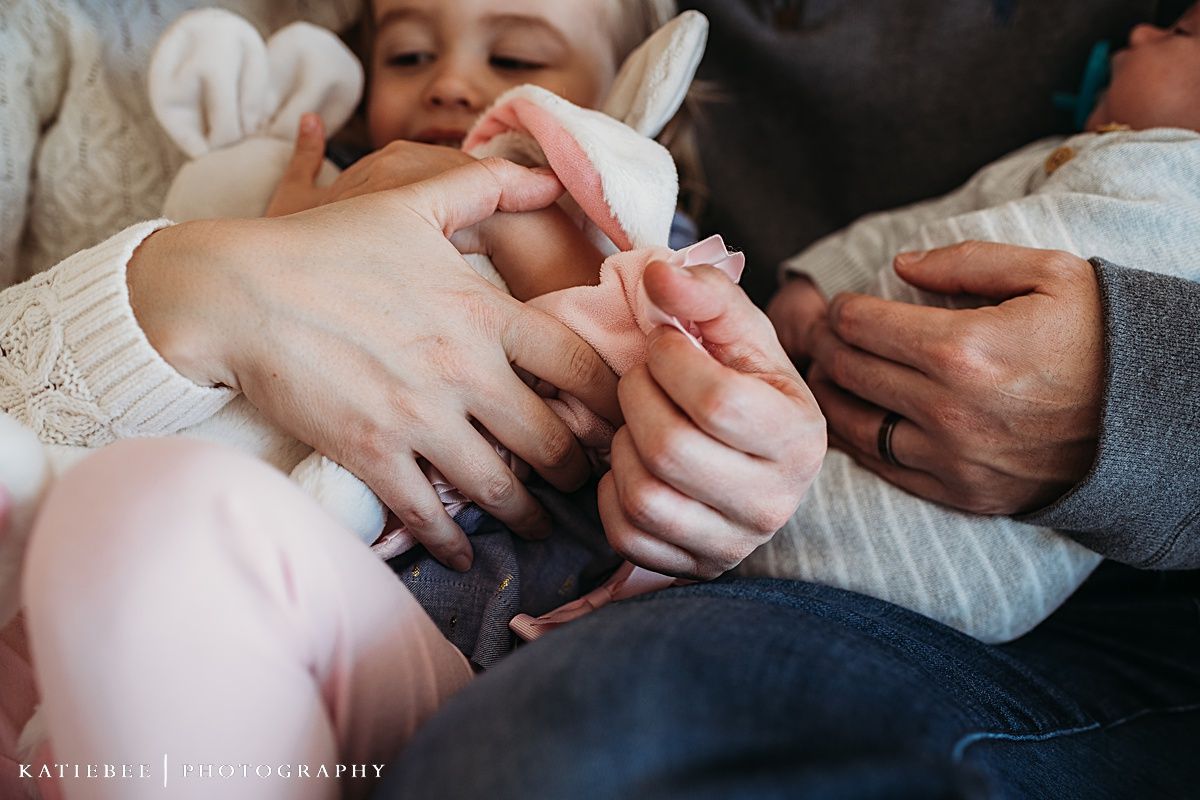 Close up shot of hands holding and playing with a small infant.