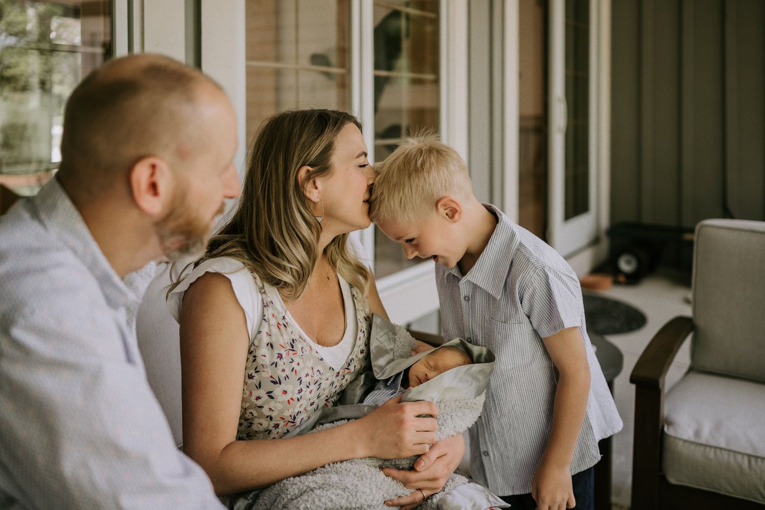 Family sharing a tender moment together on a porch while enjoying each other's company.