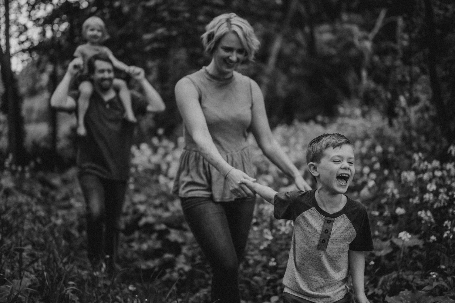 Black and white photo of joyful outdoor playtime in a flowering garden.