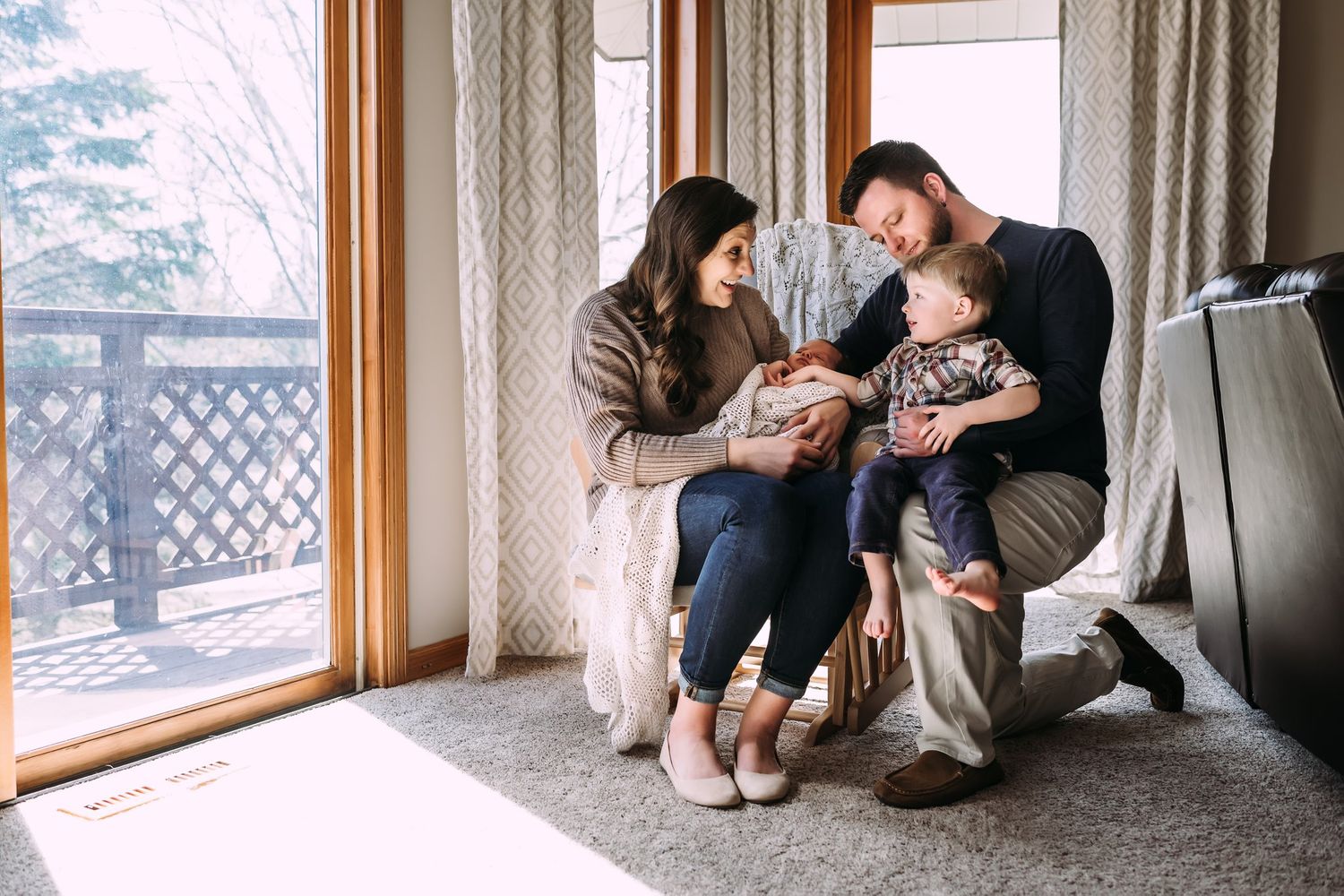 Family gathered by window sharing tender moment in natural light.
