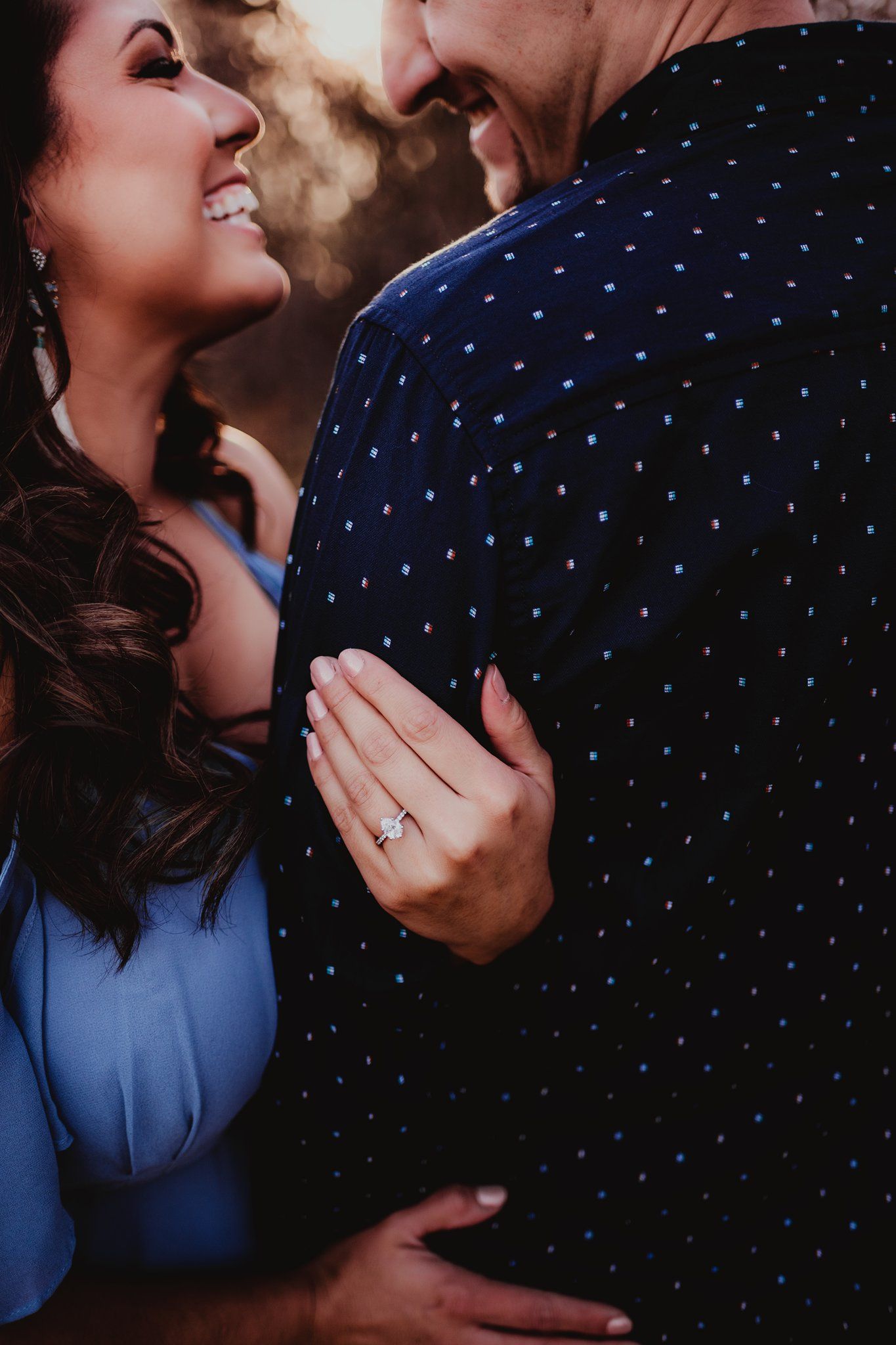 Close-up portrait showing hands and smiles during an intimate engagement session.