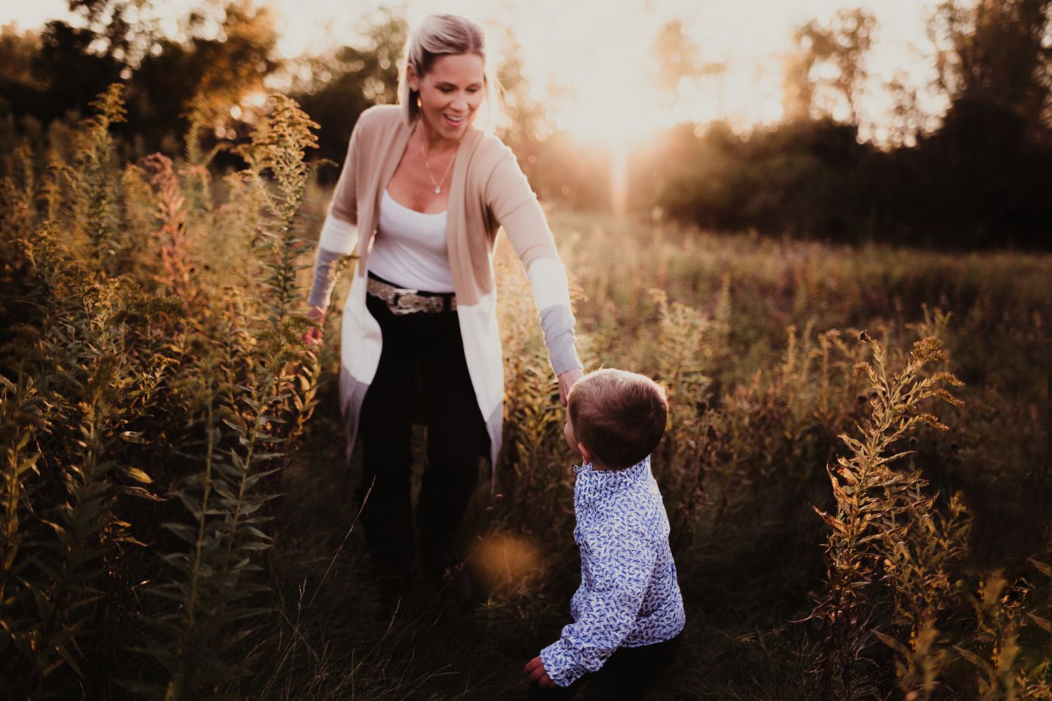 A heartwarming sunset portrait session in tall grass and warm lighting.