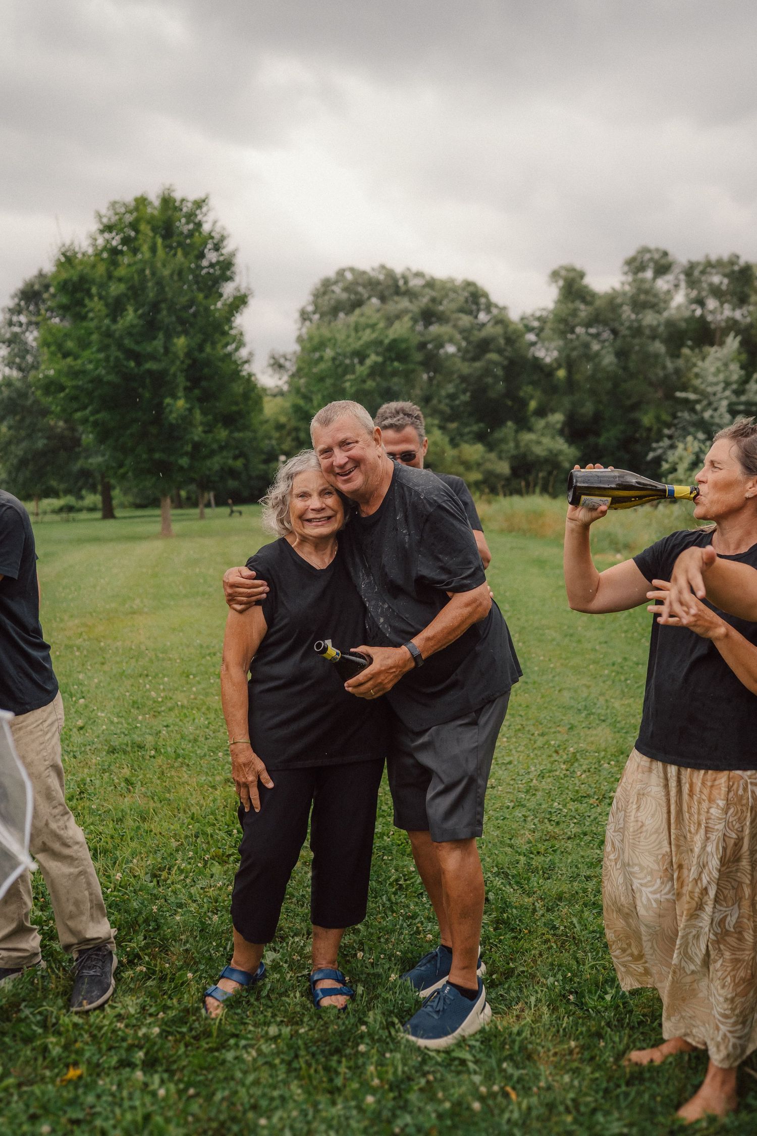 Candid moments captured of people laughing and joking together in a grassy field.