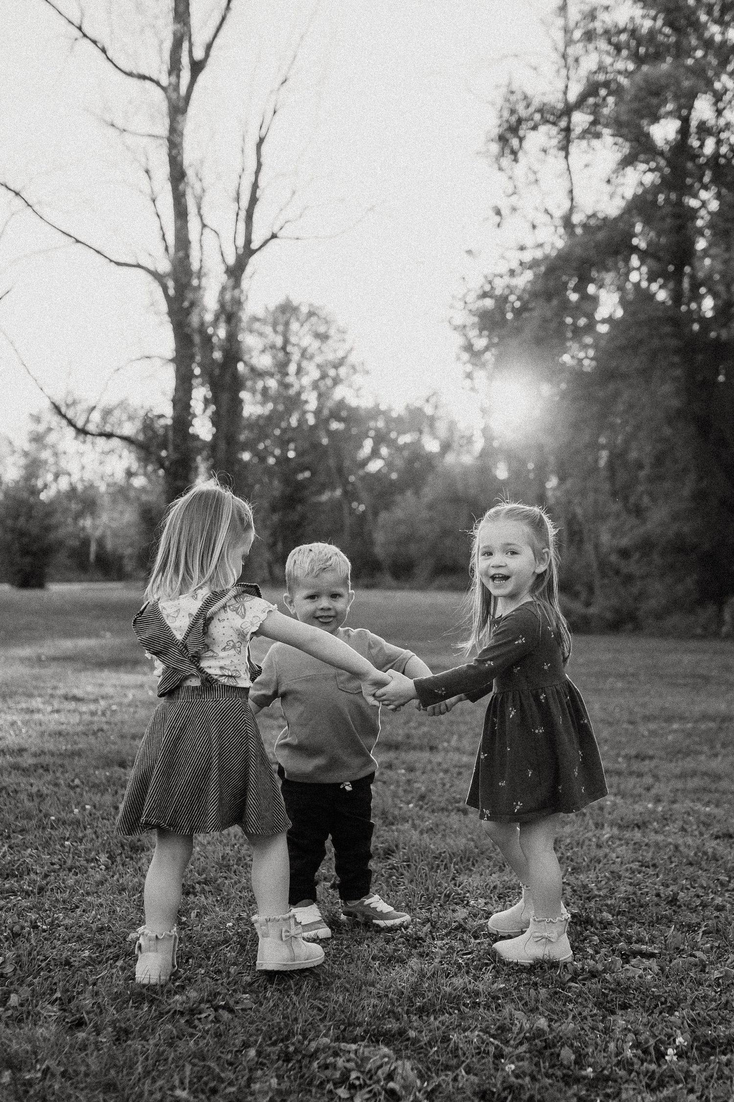 Black and white sequence showing children playing and spinning in a field.