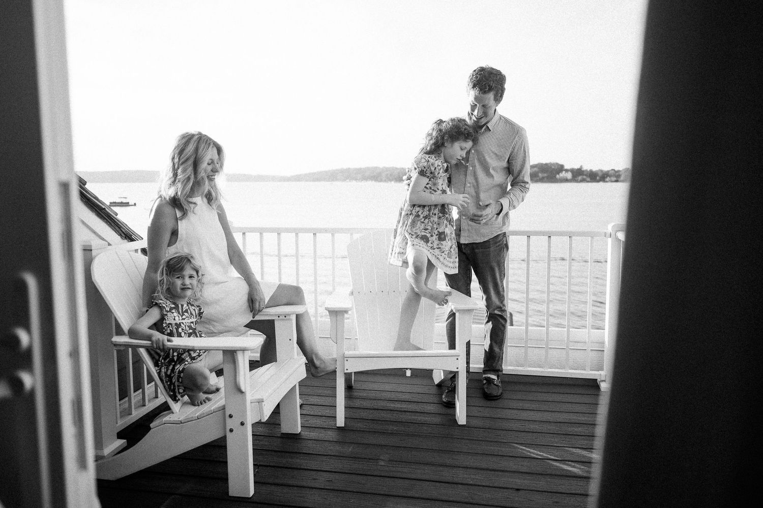 Silhouettes of people enjoying a peaceful moment on a waterfront deck.