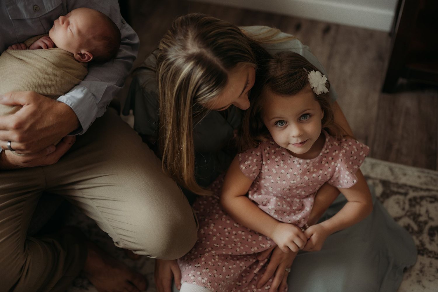 Candid family lifestyle portrait in muted tones on living room couch.