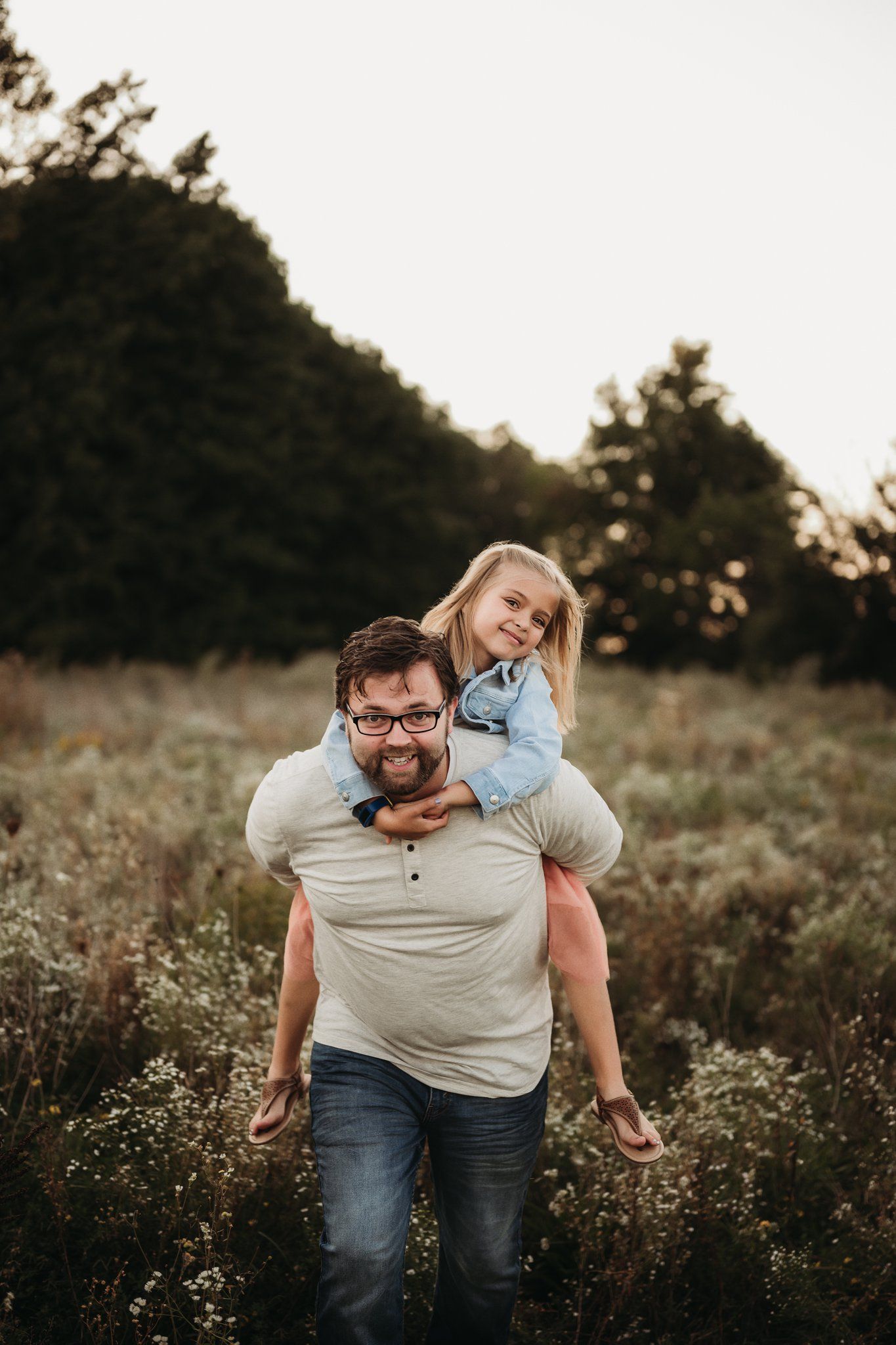 A piggyback ride moment captured against a natural backdrop during sunset.
