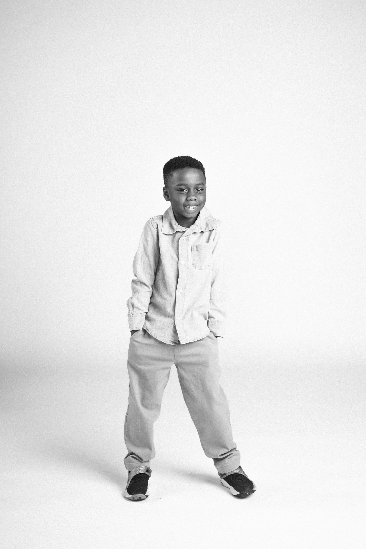 A young child in white clothing poses playfully against a light background in a series of dynamic studio shots.