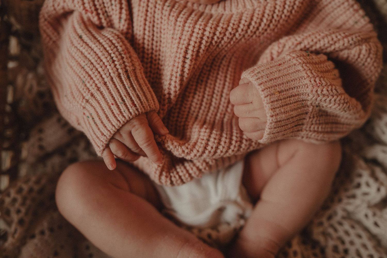Detailed macro shots of cozy knitted fabric in warm peachy tones.