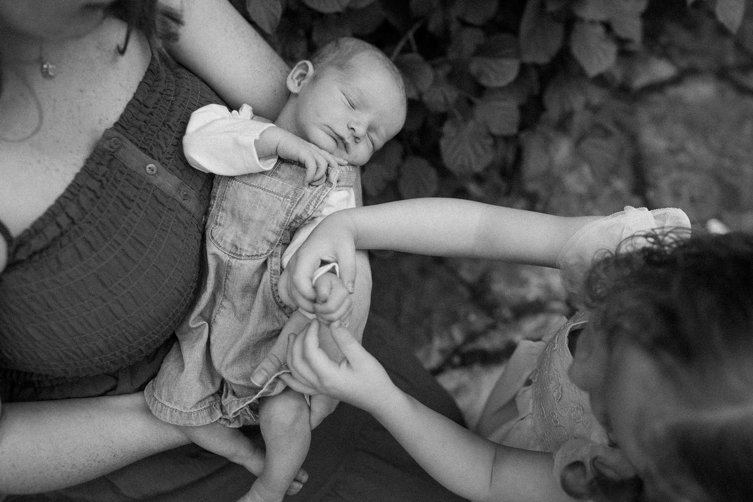 A black and white photo collage showing various shots of a baby receiving medical care and examination.