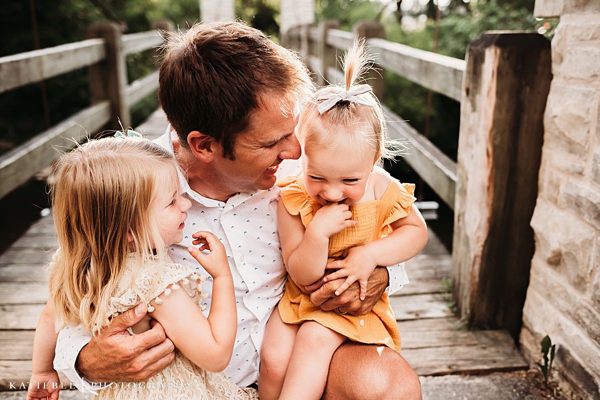 Heartwarming family moment captured on a wooden bridge during sunset.