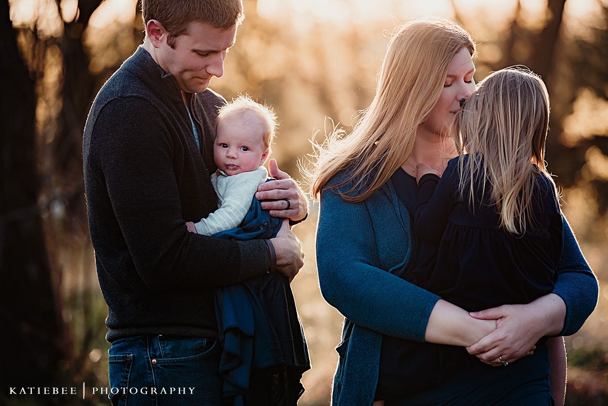 Family shares tender moments together during golden hour photo session.