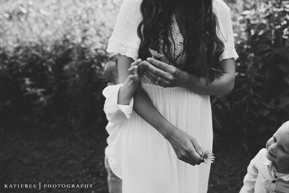 A person in a white dress holds a book in their hands against a blurred outdoor background.