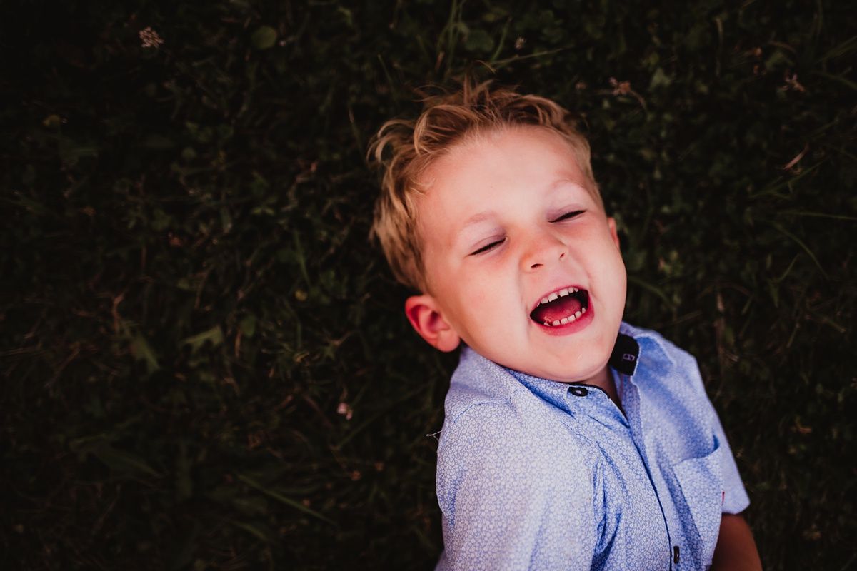 Close-up portrait of a joyful expression against a dark background.