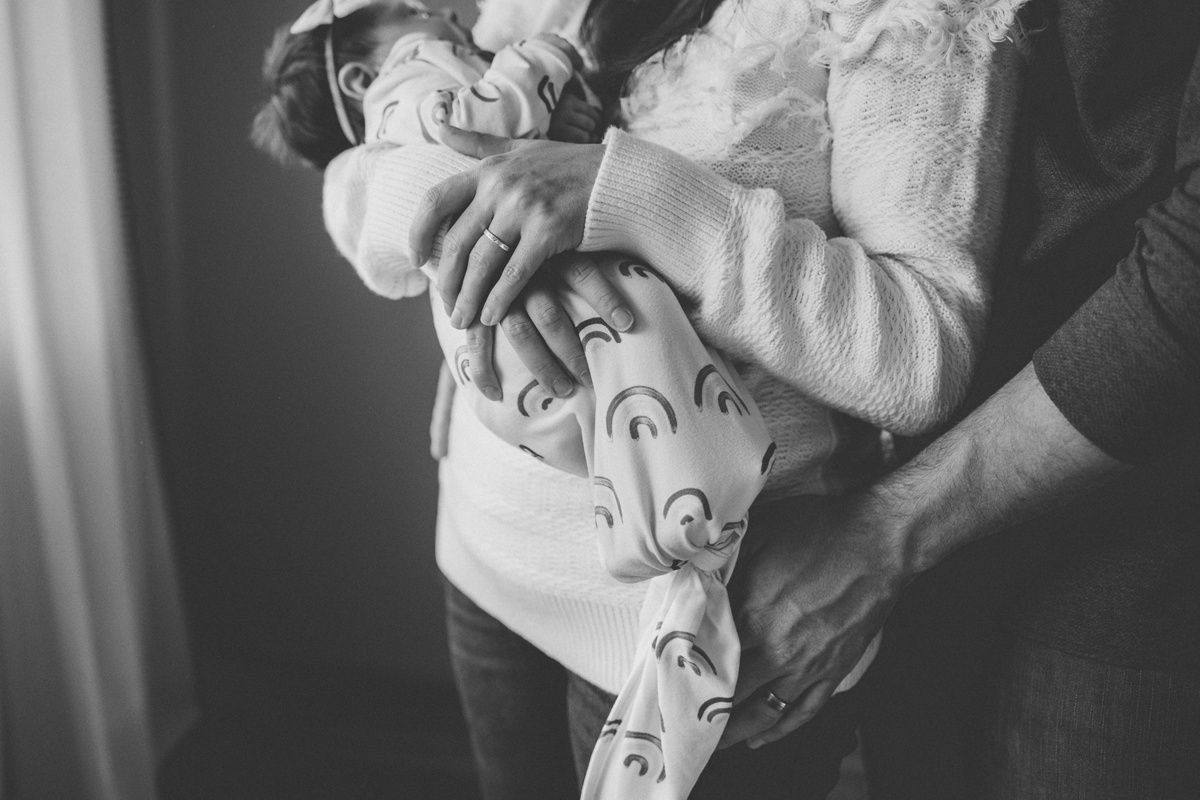 Black and white portrait of a baby being cradled in soft clothing.