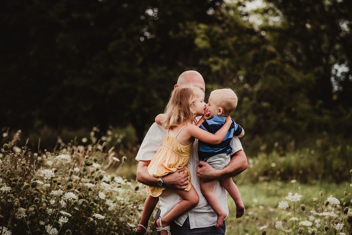 Outdoor family portrait in a wildflower meadow during golden hour.