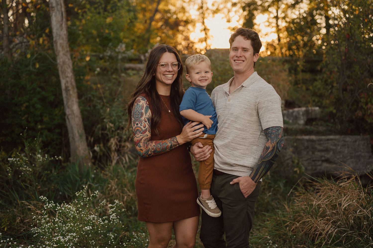Family portrait session in a natural outdoor setting with warm evening light.