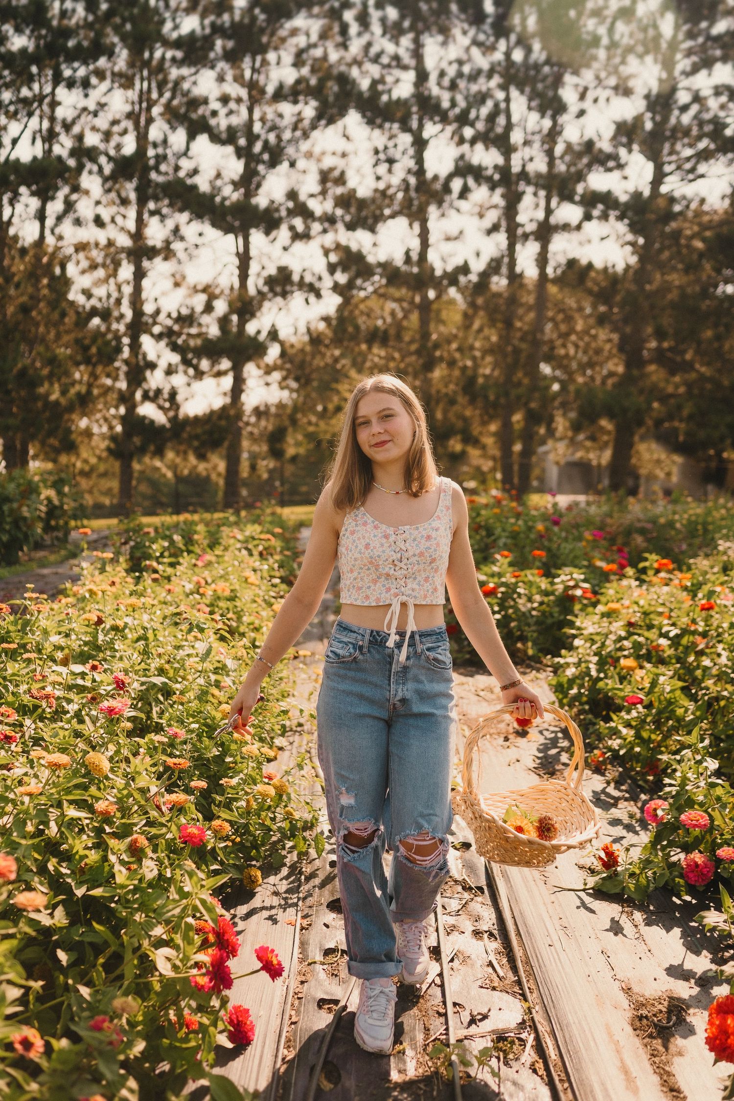 A garden portrait surrounded by blooming roses and zinnias with rustic wooden planks in the background.