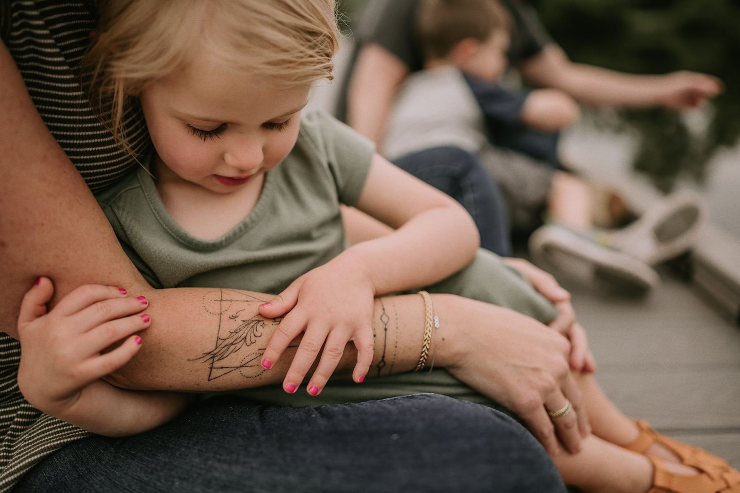 Close-up detail shot of hands and tattoo during quiet moment on dock.