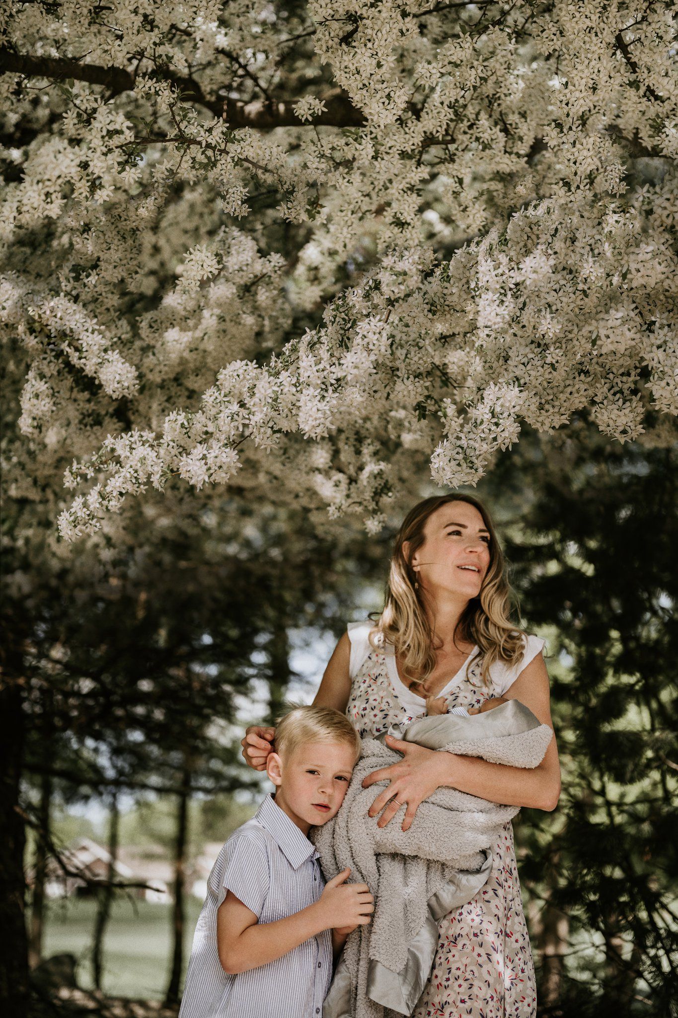 Mother and child gazing up at beautiful cherry blossoms overhead.