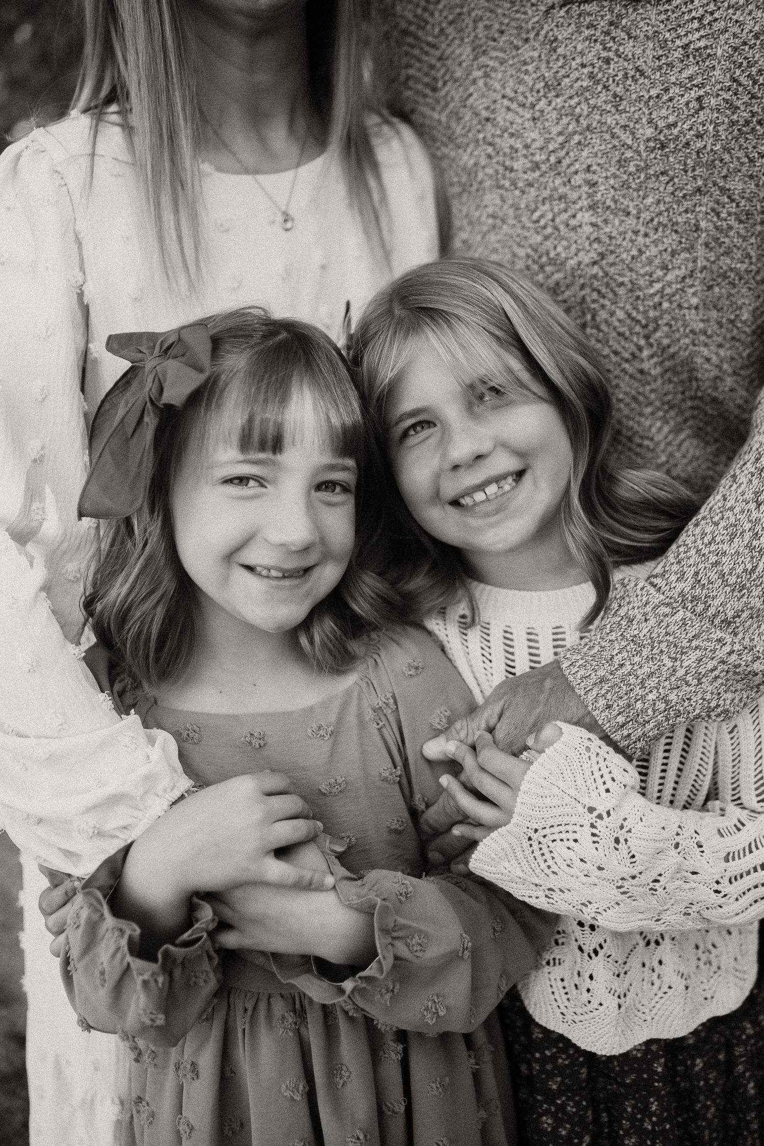 Close-up black and white portrait of two children wearing vintage-style lace dresses.
