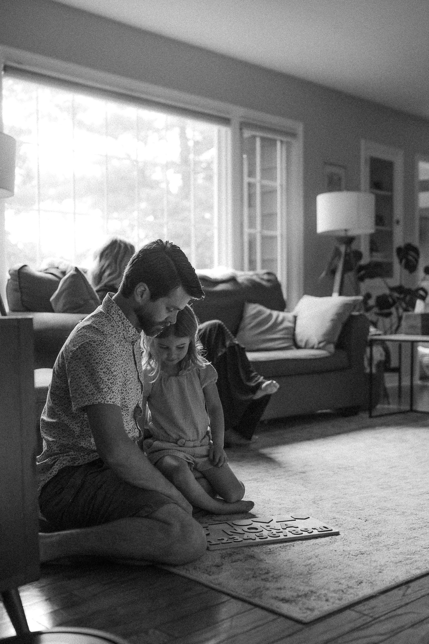 A sequence of images showing quiet moments playing a board game on hardwood floors.