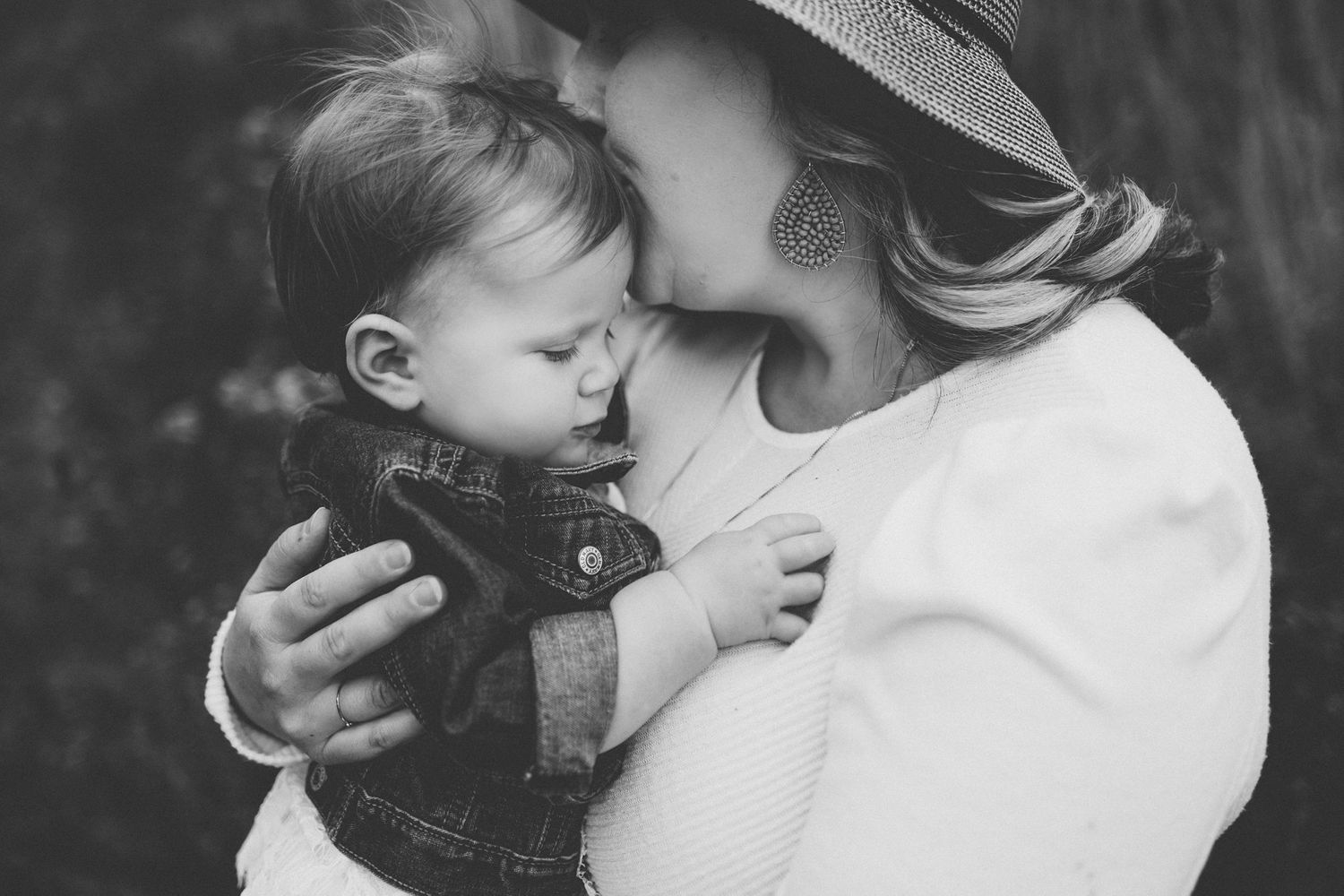 A black and white intimate portrait showing a tender embrace outdoors.