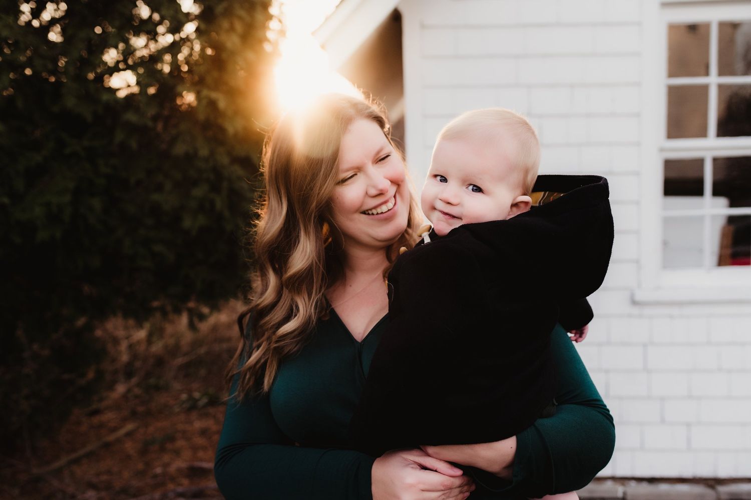 Heartwarming candid moment against white house exterior during sunset.