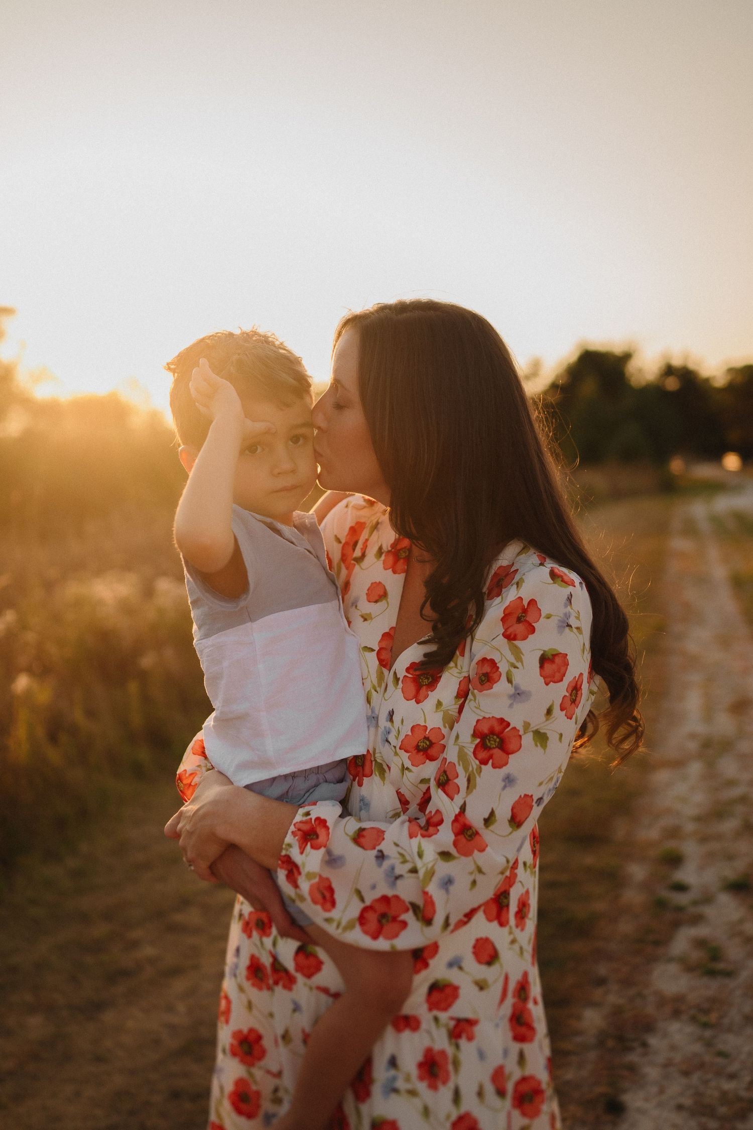Intimate family portrait captured during golden hour on a rustic dirt path.