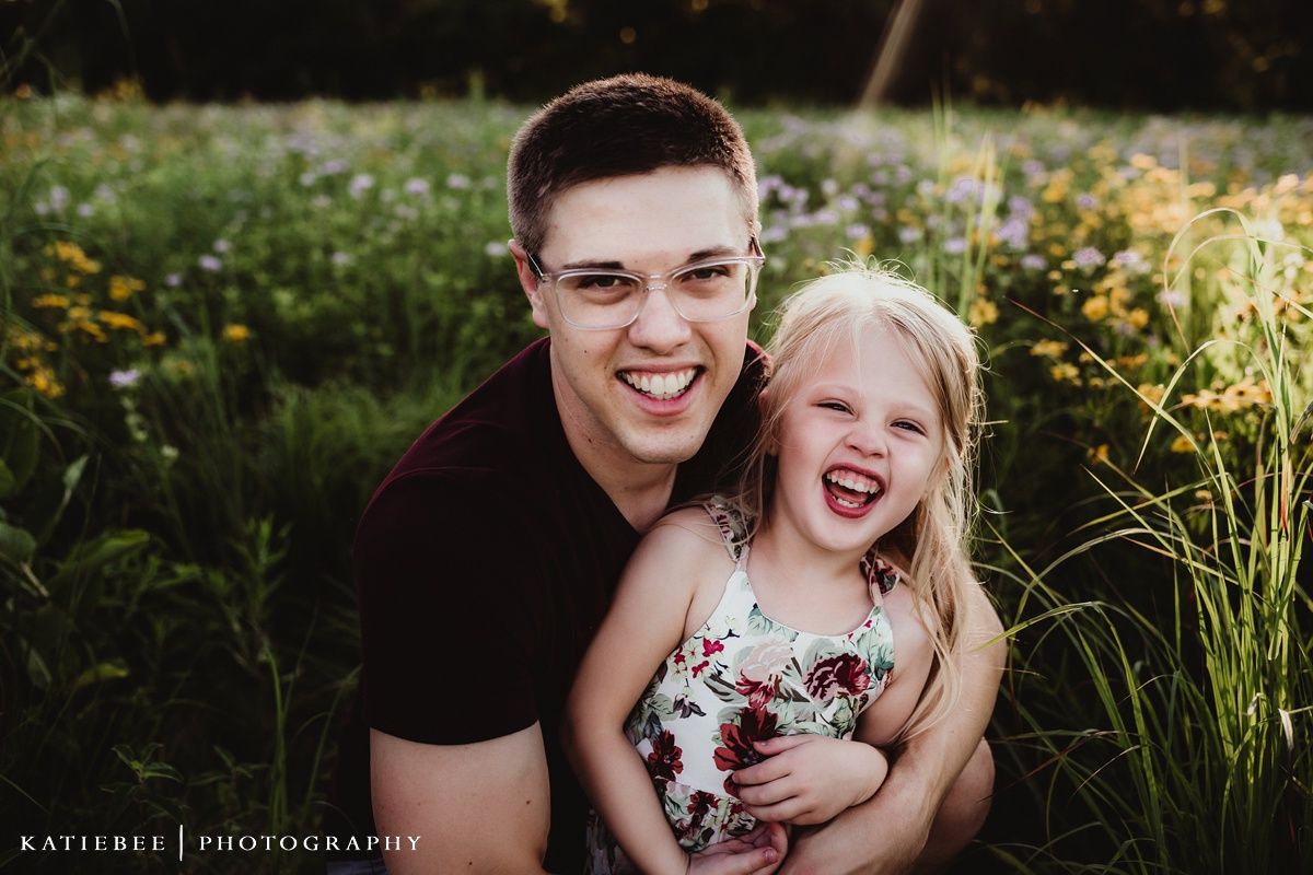 Joyful candid portrait captured in garden with blooming flowers.