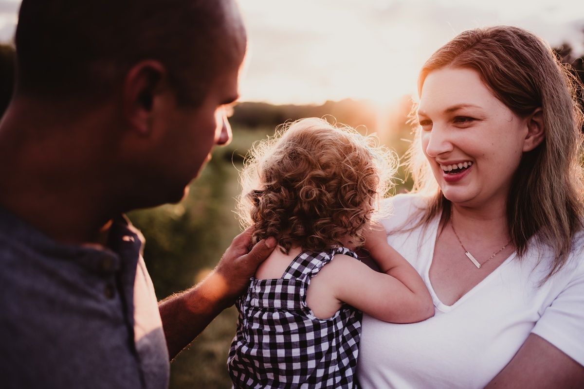 A joyful family interaction captured during golden hour in nature.