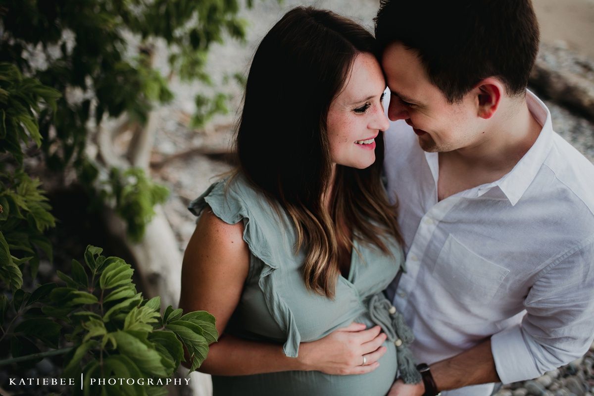 Intimate maternity portrait of couple in casual attire sharing a tender moment together.