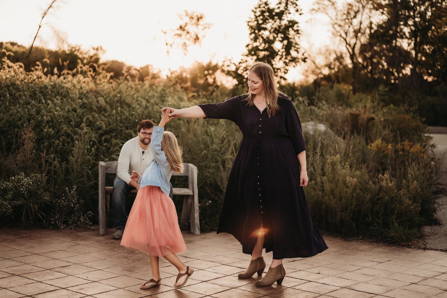 Two people dancing together on a patio during sunset.